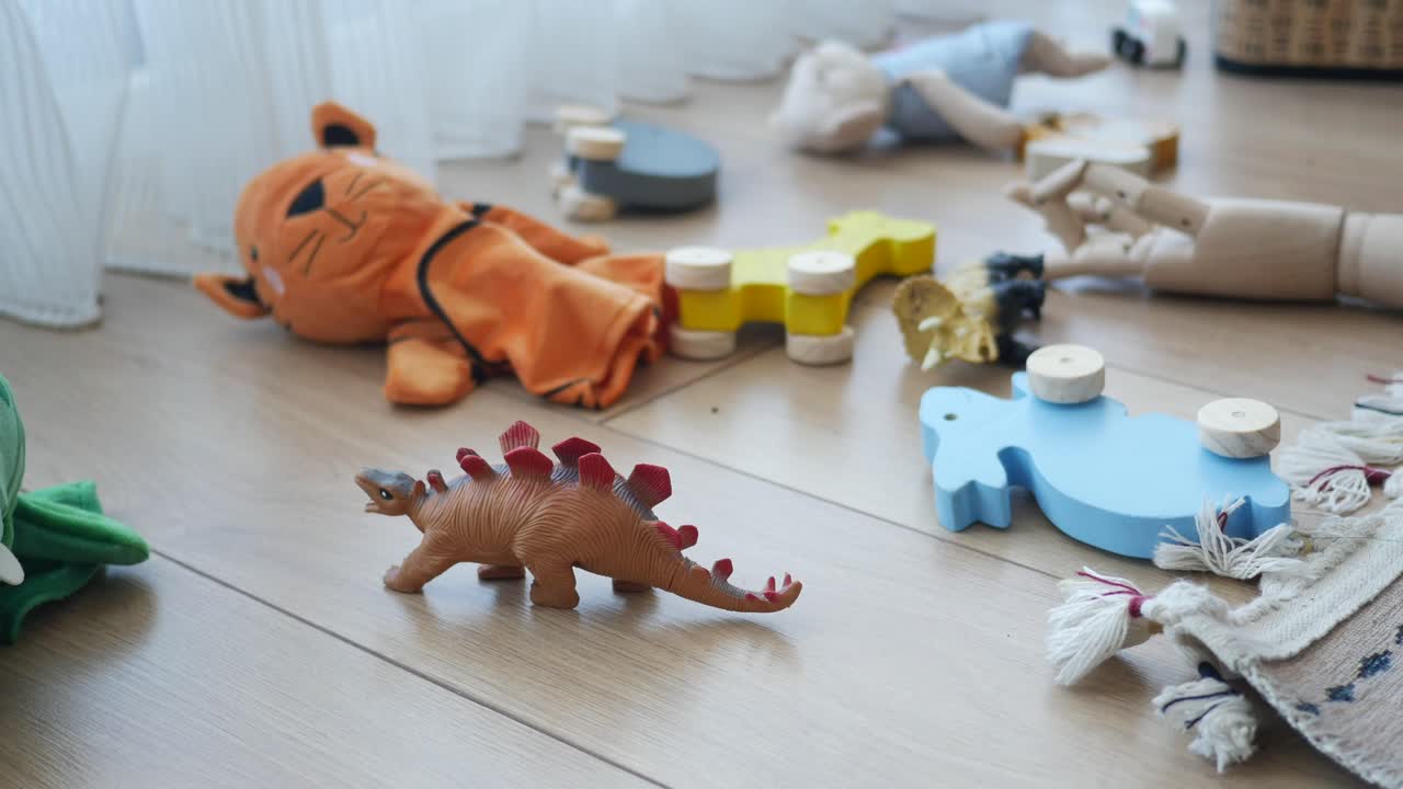 Various children's toys scattered on a wooden floor
