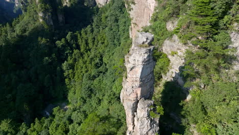 aerial view descending in front of a towering mountain pillar in zhangjiajie, china