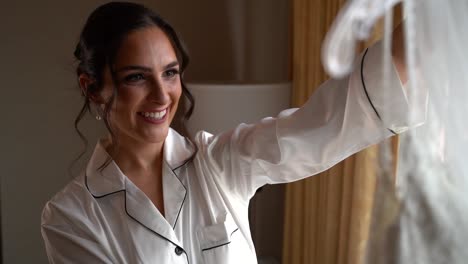 hermosa mujer morena mirando su vestido antes de la boda 02