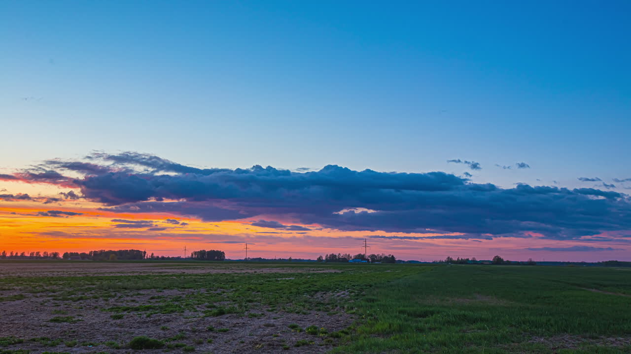 일몰 후 다채로운 하늘에서 날아다니는 구름의 저속 촬영 - 자연의 진흙 투성이 풀밭에 정적 와이드 샷