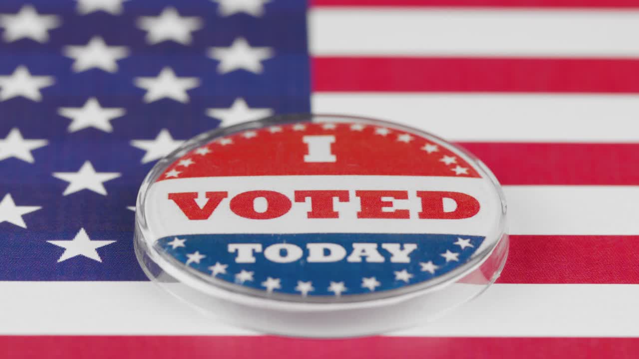 4k resolution tilt movement of i voted today button on the US flag. USA elections concept