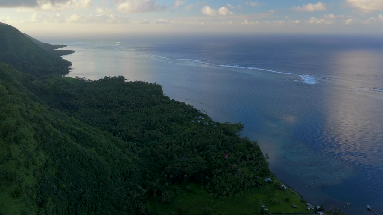 Teahupoo Tahiti bay shoreline sunrise yellow golden hour sunset aerial drone view from mountain peaks to coral reef French Polynesia WSL Surfing summer Olympic venue town village circle right motion