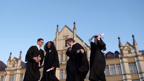 group of diverse graduation students throwing their mortarboards into the air