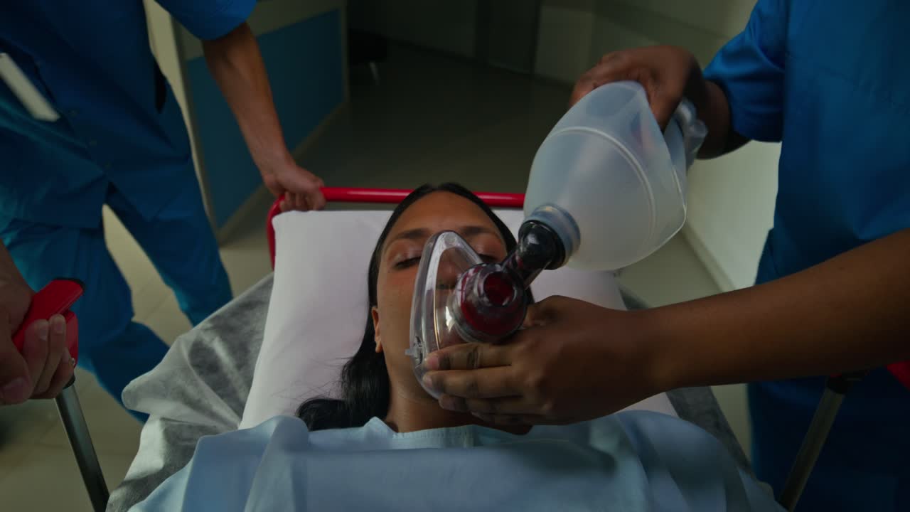 personal médico que proporciona apoyo respiratorio al paciente en camilla