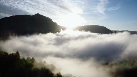 Vista-Frontal-De-Un-Dron-Que-Viaja-De-Una-Montaña-Y-Nubes