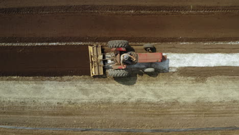 tractor rojo arando el campo y surcando en una plantación, concepto agronómico, disparo de drones en ascenso cenital