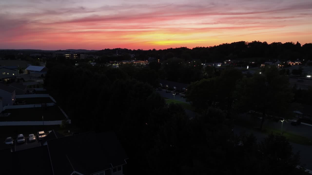 Dark housing area in suburb of american town at golden Sunset. Aerial wide shot. Lighting lantern and sky with mystic clouds. Dusk scene in quiet american housing area.