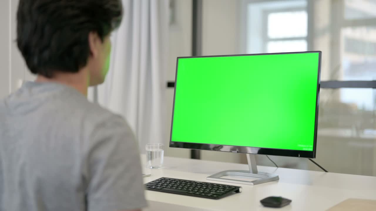 녹색 크로마 키 스크린을 가진 데스크에서 비즈니스맨의 비디오 통화