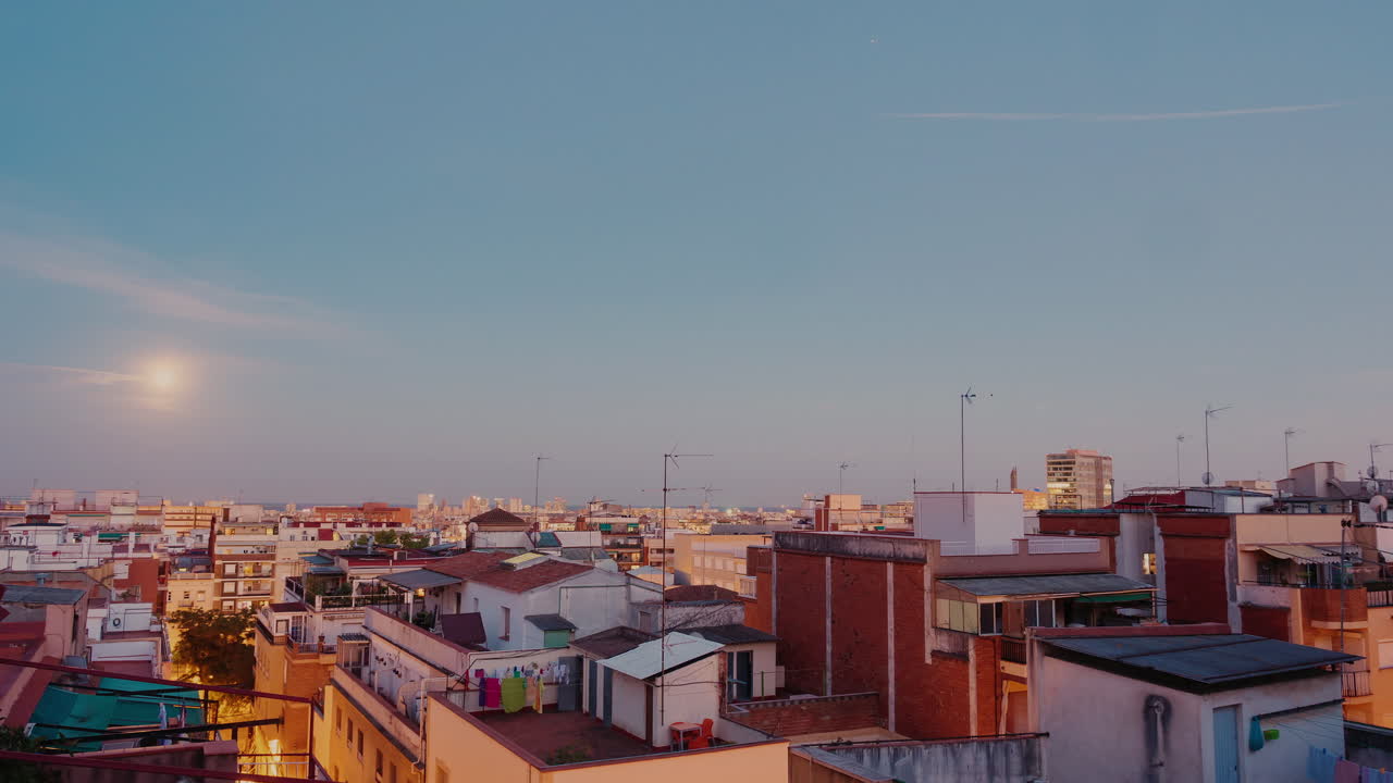 Alba della luna sulla città e sui tetti delle case. Timelapse dalla sera all'alba. Il sole sorge sopra il