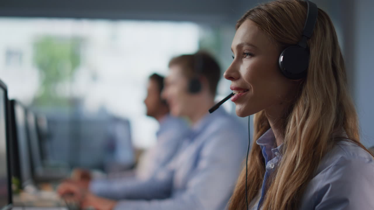 Customer service team working at modern call center closeup. Helpdesk staff