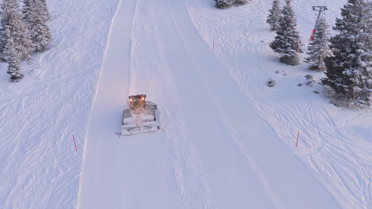 Avusturya'daki Zillertal Arena, Krimml ve Königsleiten'de, karla kaplı dağlar eşliğinde Pistebully makinelerinin düzenli kayak pistleri oluşturduğu havadan drone çekimi.