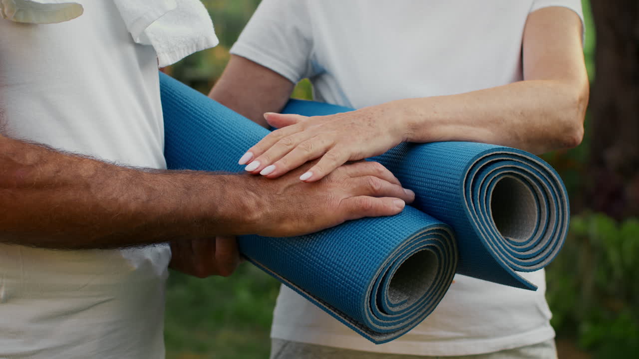 Couple Holding Yoga Mat Outdoors
