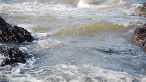 Waves-hitting-rocks-on-coast,-slow-motion-close-up