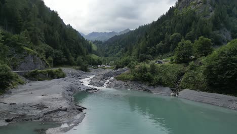 Fluss,-Der-Durch-Einen-üppigen-Wald-Fließt,-Umgeben-Von-Bergen,-Märchenhafte-Landschaft,-Kanufahren-Entlang-Des-Flusses,-Berge-Mit-Bäumen-An-Den-Hängen-Und-Gipfeln,-Die-In-Neblige-Wolken-Gehüllt-Sind