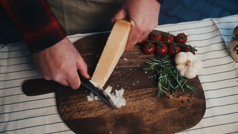 parmesano rallado en una tabla de madera con tomates, ajo y romero cerca