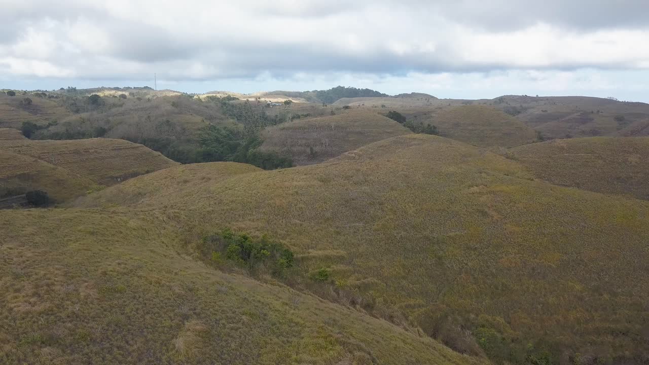 Vista aerea delle colline dei Teletubbies a Nusa Penida, Bali, durante una giornata nuvolosa, coperte da erba rigogliosa e verde.