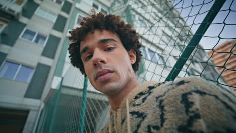 trendy hipster posing street looking down closeup. curly latino model at city