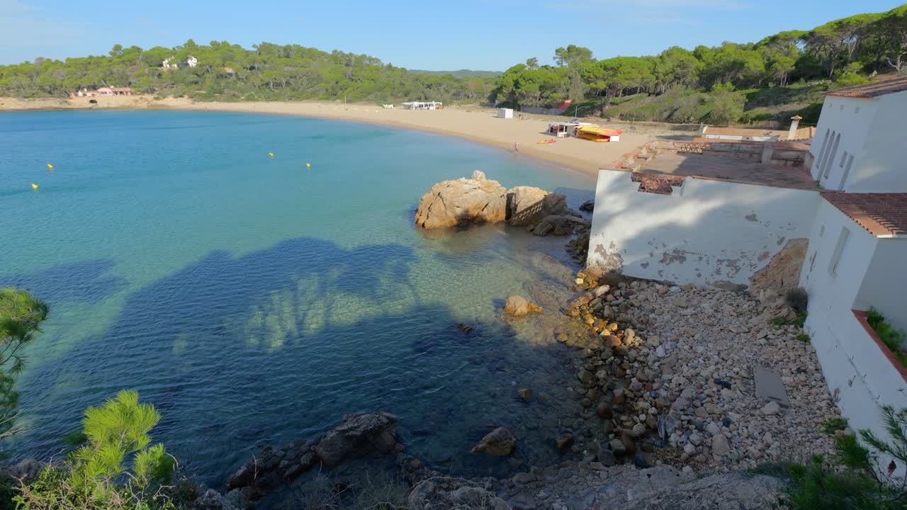 Splendida spiaggia soleggiata con acqua cristallina e edificio bianco