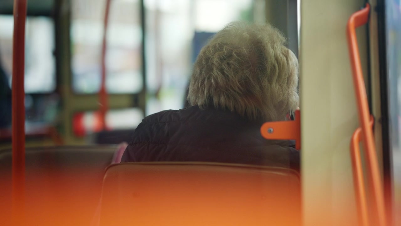 Vista interna con messa a fuoco morbida di un passeggero seduto all'interno di un veicolo di trasporto pubblico