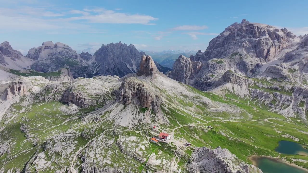 Panorama aereo delle Tre Cime di Lavaredo e di un rifugio alpino delle Dolomiti 4K.