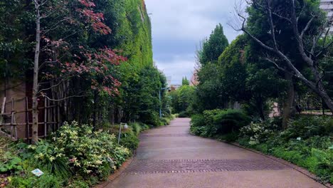 a peaceful garden path lined with lush greenery on a cloudy day
