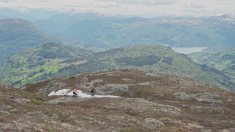 epic mountain biking adventure above the fjords near sogndal, norway. rider tackles rugged trails surrounded by dramatic cliffs, lush green hills, and stunning nordic scenery