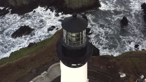 primer plano aéreo cinematográfico, faro principal de yaquina con vistas a las olas, destino turístico