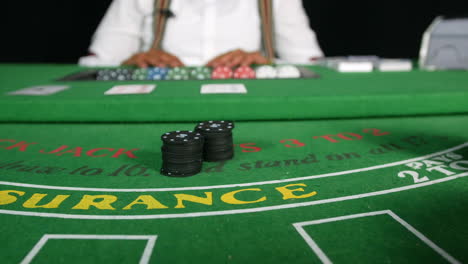 poker players placing bets with poker chips on a black jack tabble in a casino close up