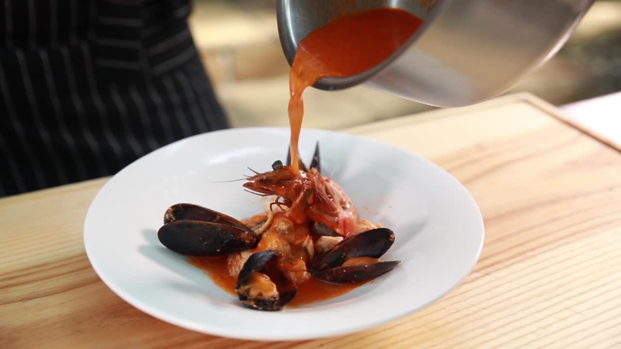 요리사 가 해산물 수프 를 준비 하고 있다