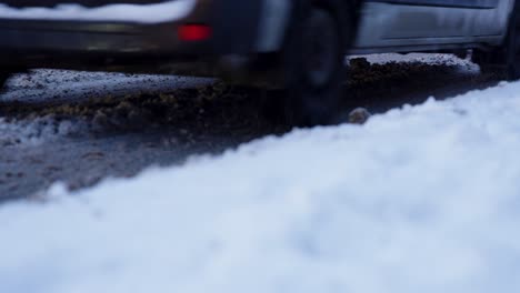 wheels of cars driving on the snowy road