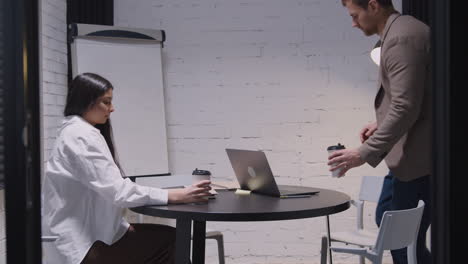 businessman and businesswoman with takeaway coffee entering in meeting room