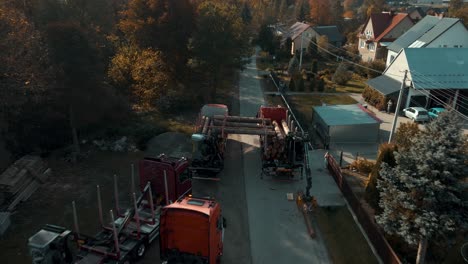 aerial view of timber trucks loading tree logs on the street