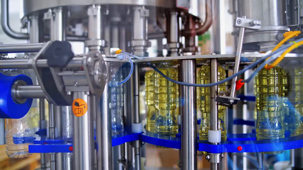 Sunflower oil production plant. Bottles filled with sunflower oil through special tubes