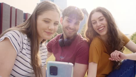 grupo de estudiantes caucásicos tomando selfies fuera del campus universitario