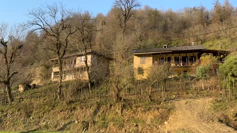 Morning-sun-on-the-wooden-house-eco-lodge-in-the-mountain-hills-highland-of-Iran-in-middle-east-traditional-culture-agriculture-to-work-on-farmland-native-cuisine-wood-architecture-design-Iran-forest