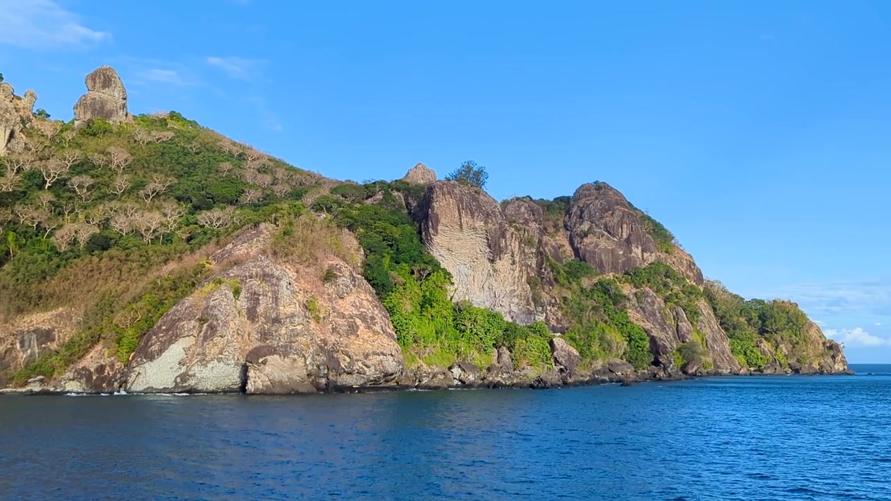 Isola tropicale remota, aspra e rocciosa con acqua blu dell'oceano nelle Isole Yasawa, Fiji, Pacifico meridionale.