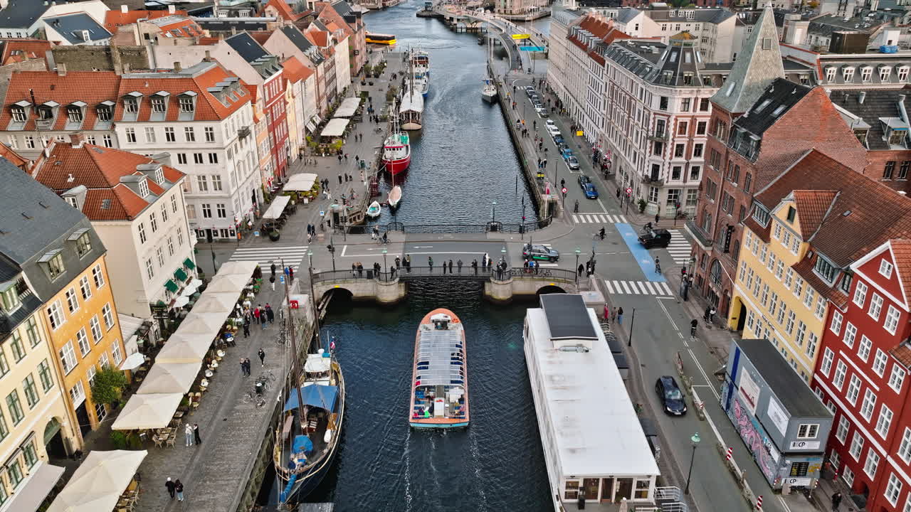 Aerial drone view of boats on the Nyhavn waterfront, canal and entertainment district in Copenhagen, Denmark in daylight