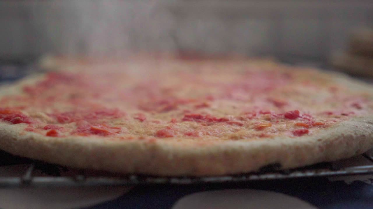 primer plano de una pizza casera caliente recién salida del horno lista para colocar el relleno y terminar la cocción