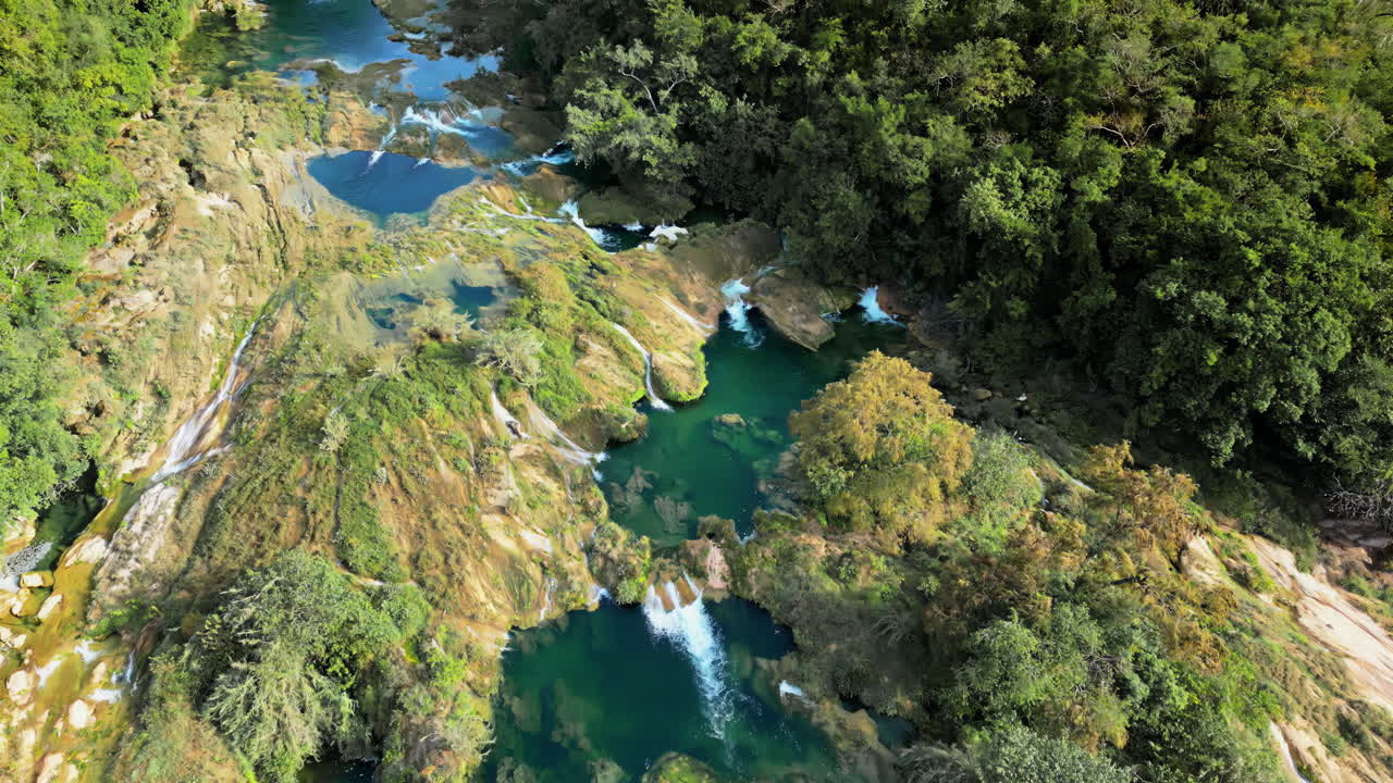 Vista aerea da drone della cascata Tamul che scende a cascata dalle verdi scogliere in una piscina turchese sottostante al rallentatore