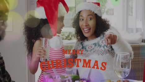 Animation-of-merry-christmas-over-happy-african-american-mother-and-daughter-in-santa-hats