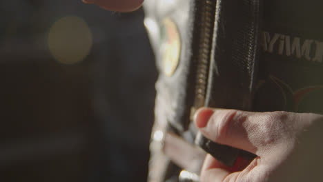 cowboy zips up his leather jacket before a bull riding rodeo event in texas.