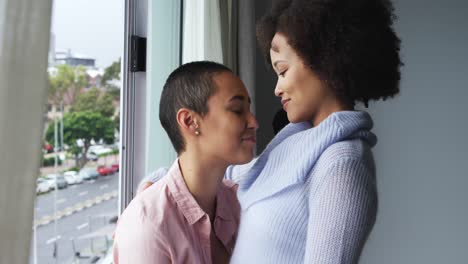 lesbian couple romancing at window