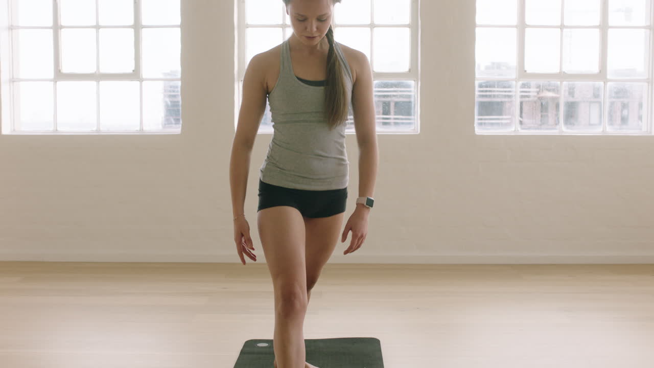 mujer de yoga saludable practicando pose de perro boca abajo disfrutando de un estilo de vida fitness haciendo ejercicio en un estudio de entrenamiento en una colchoneta de ejercicios al amanecer.