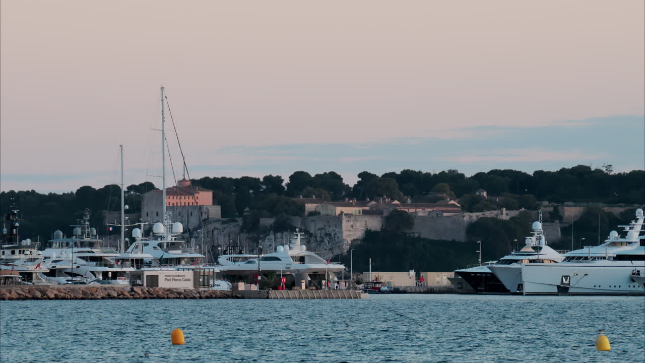 Multiple boats docked in the Port Pierre Canto in Cannes, France in the evening