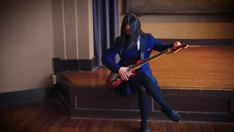 japanese high school girl tunes guitar for band practice