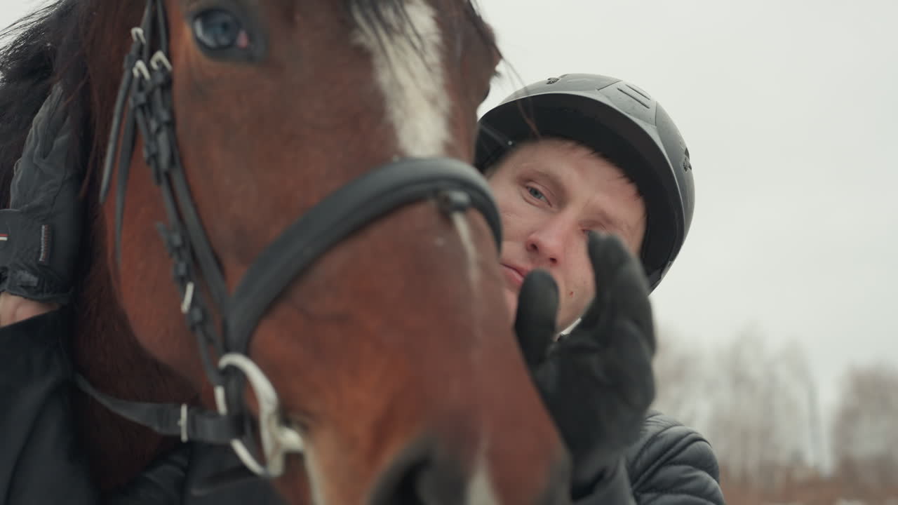 L'istruttore guida il cavallo con calma. Primo piano dell'istruttore che assiste il cavaliere durante una sessione di equitazione invernale. Un momento educativo che mostra l'istruttore che favorisce la fiducia tra cavaliere e cavallo con una guida delicata.
