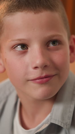 schoolboy looks at entering woman with friendly smile. cheerful son spends time with mother. kid shows positive emotions on blurred background closeup