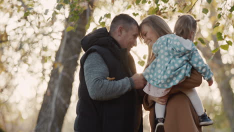 familia feliz con un niño divertirse en el parque de otoño