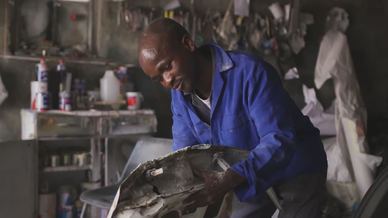 African man sanding a car