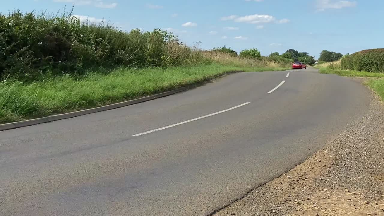 Cars Driving on a Rural Road on a Sunny Day